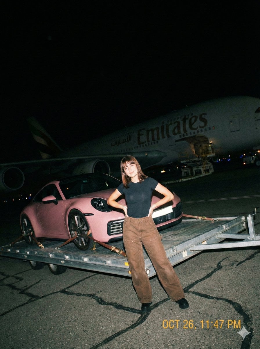 A gritty, handheld iPhone photo taken at night on an airport tarmac with harsh direct on-...