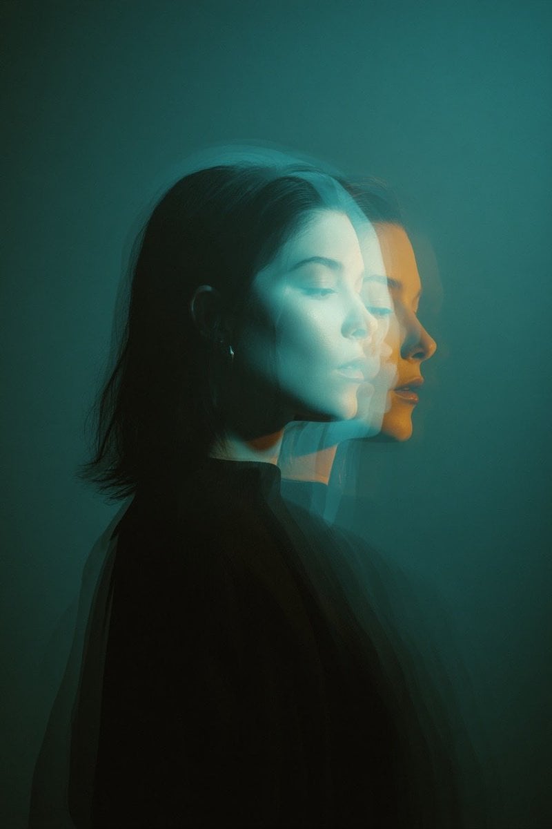 Cinematic double exposure portrait of a woman in side profile, two overlapping faces slig...